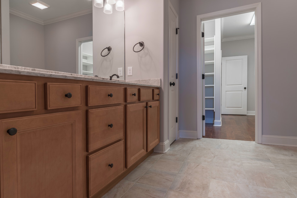 Alcove shower - mid-sized transitional master beige tile and ceramic tile ceramic tile alcove shower idea with shaker cabinets, medium tone wood cabinets, beige walls, an undermount sink and granite countertops