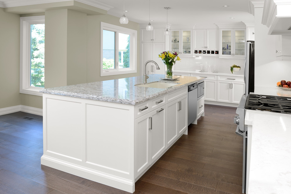 Inspiration for a mid-sized transitional l-shaped medium tone wood floor and brown floor eat-in kitchen remodel in Toronto with an undermount sink, shaker cabinets, white cabinets, quartz countertops, white backsplash, subway tile backsplash, stainless steel appliances and an island