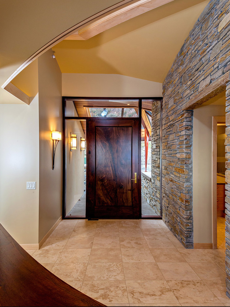 Inspiration for a mid-sized contemporary foyer in Seattle with beige walls, travertine floors, a single front door and a dark wood front door.