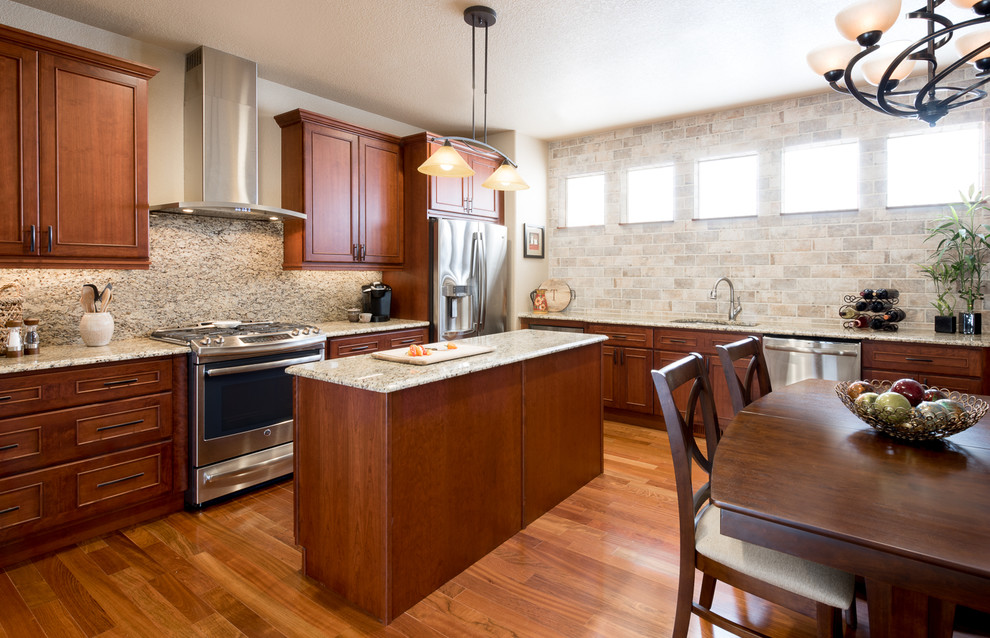 Inspiration for a mid-sized transitional l-shaped medium tone wood floor and brown floor eat-in kitchen remodel in Denver with an integrated sink, recessed-panel cabinets, medium tone wood cabinets, granite countertops, beige backsplash, mosaic tile backsplash, stainless steel appliances and an island