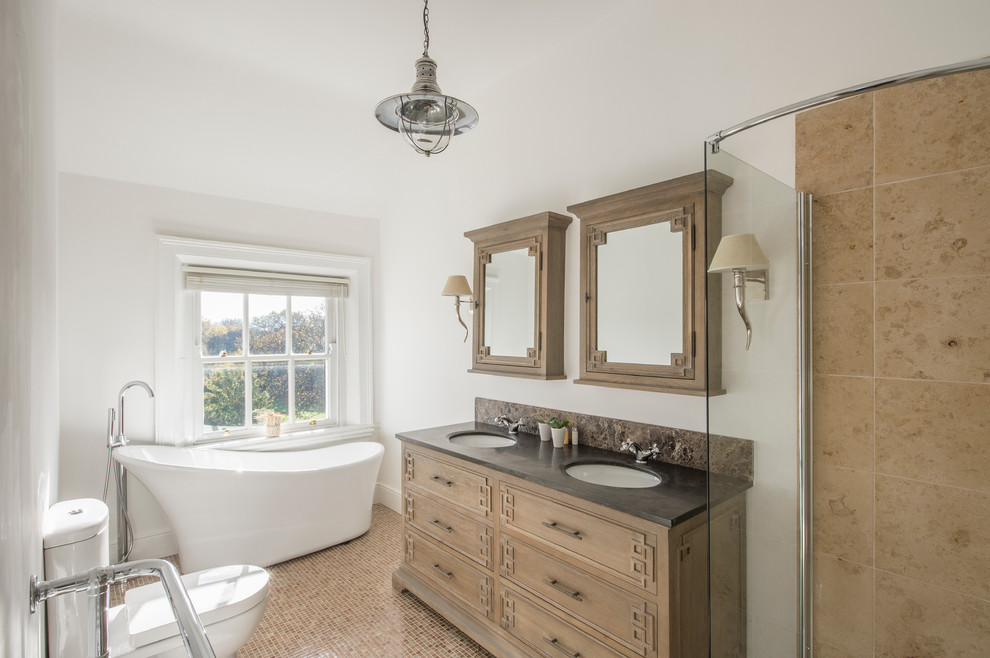 Design ideas for a large traditional master bathroom in Dublin with an undermount sink, light wood cabinets, granite benchtops, a freestanding tub, a one-piece toilet, beige tile, ceramic tile, white walls, mosaic tile floors and recessed-panel cabinets.