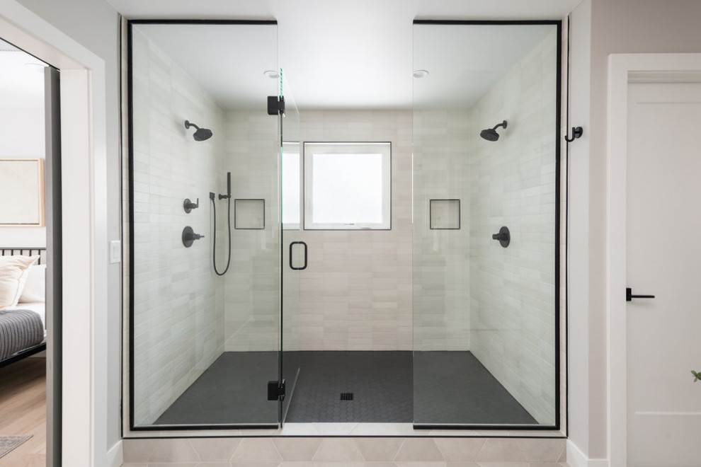 На фото: большой главный совмещенный санузел в стиле неоклассика (современная классика) с двойным душем, белой плиткой, керамогранитной плиткой, серыми стенами, полом из керамогранита, серым полом и душем с распашными дверями с