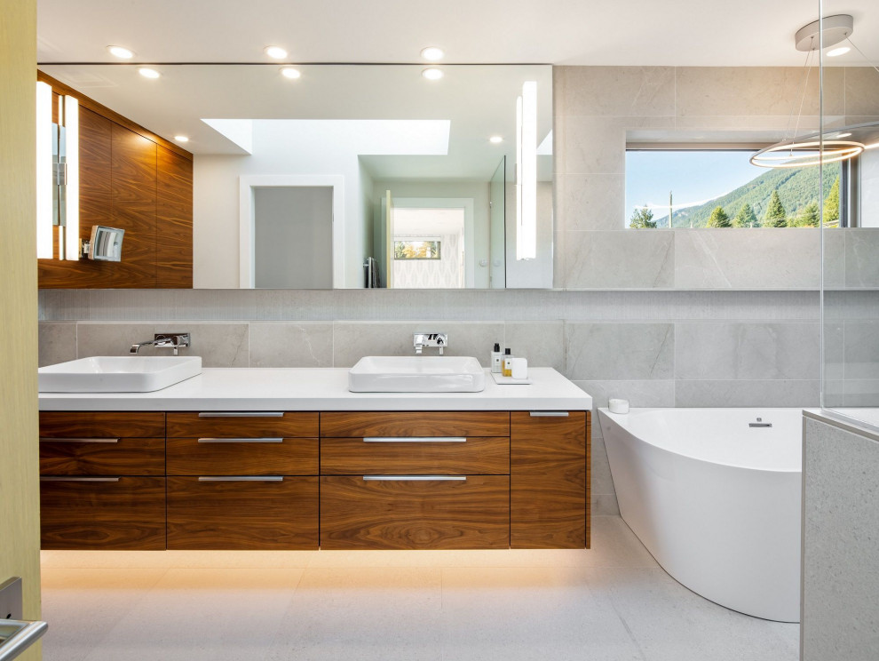 Design ideas for a large contemporary bathroom in Vancouver with medium wood cabinets, gray tile, engineered quartz benchtops, white floor, white benchtops, flat-panel cabinets, a double vanity and a floating vanity.