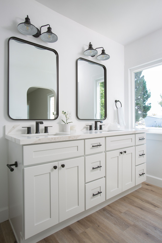 Photo of a mid-sized transitional kids wet room bathroom in Los Angeles with beaded inset cabinets, white cabinets, laminate floors, brown floor, a one-piece toilet, white tile, white walls, an undermount sink, engineered quartz benchtops, white benchtops, a single vanity, a built-in vanity and a hinged shower door.