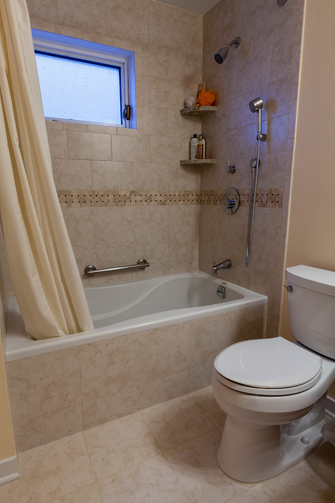 Design ideas for a mid-sized transitional bathroom in Bridgeport with an undermount sink, raised-panel cabinets, medium wood cabinets, granite benchtops, an alcove tub, a shower/bathtub combo, a two-piece toilet, beige tile, porcelain tile, beige walls and porcelain floors.