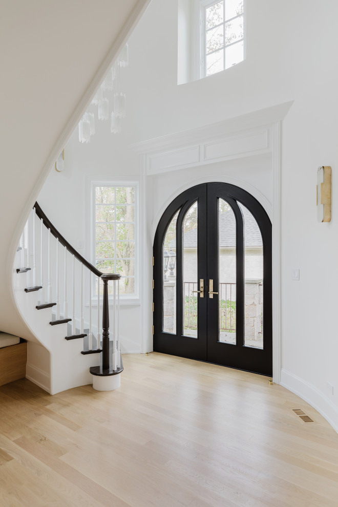 Elegant Home Interior Entrance With Curved Staircase and Black Double Doors