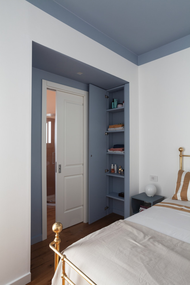 Immagine di una camera matrimoniale minimal con pareti blu, parquet scuro e abbinamento di mobili antichi e moderni