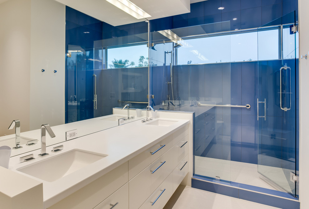 Photo of a mid-sized contemporary master bathroom in Tampa with an undermount sink, flat-panel cabinets, white cabinets, engineered quartz benchtops, a two-piece toilet, blue tile, porcelain tile, white walls and porcelain floors.