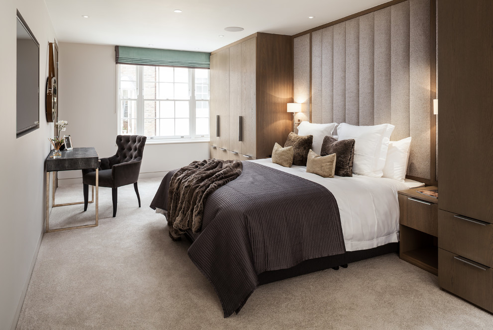 Photo of a mid-sized transitional master bedroom in London with beige walls, carpet and beige floor.