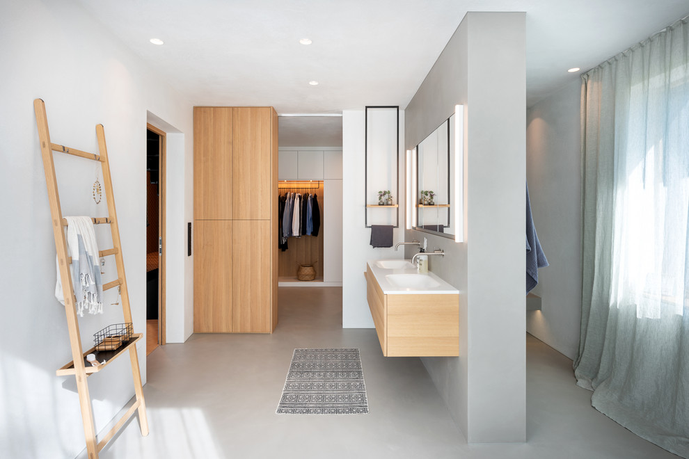 Inspiration for an expansive scandinavian master bathroom in Munich with an alcove tub, mirror tile, grey walls, concrete floors, an integrated sink, wood benchtops, grey floor and beige benchtops.