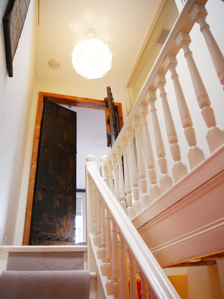 Photo of a small traditional carpeted straight staircase in New York with painted wood risers.