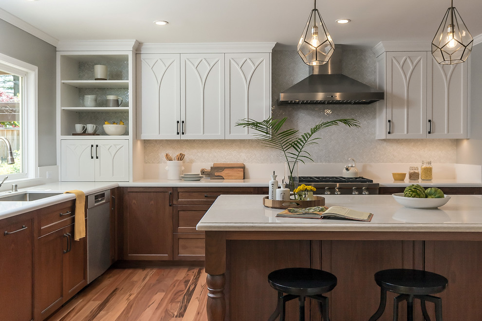 This is an example of a large traditional l-shaped kitchen in San Francisco with an undermount sink, shaker cabinets, quartzite benchtops, ceramic splashback, stainless steel appliances, with island, white benchtop, dark wood cabinets, grey splashback and medium hardwood floors.