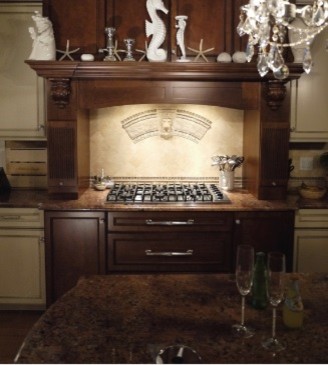 Large transitional dark wood floor kitchen photo in New York with recessed-panel cabinets, dark wood cabinets, granite countertops, beige backsplash, ceramic backsplash, paneled appliances and an island