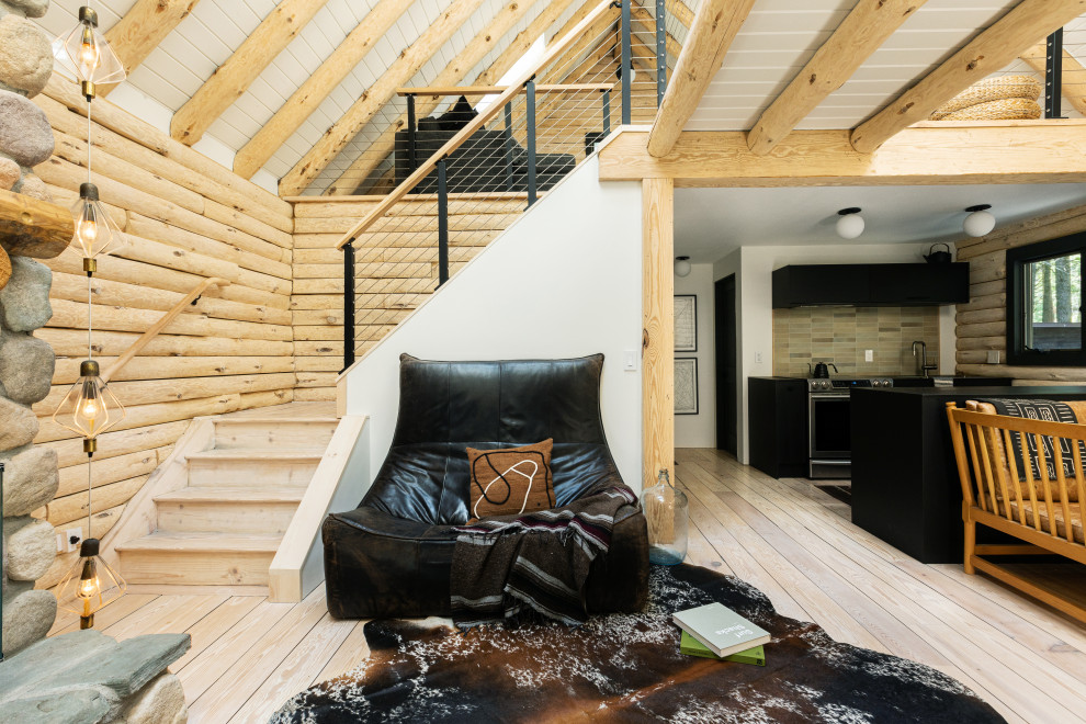 Immagine di un soggiorno minimalista di medie dimensioni e stile loft con pareti beige, pavimento in compensato, stufa a legna, cornice del camino in pietra, pavimento beige, travi a vista e pareti in legno
