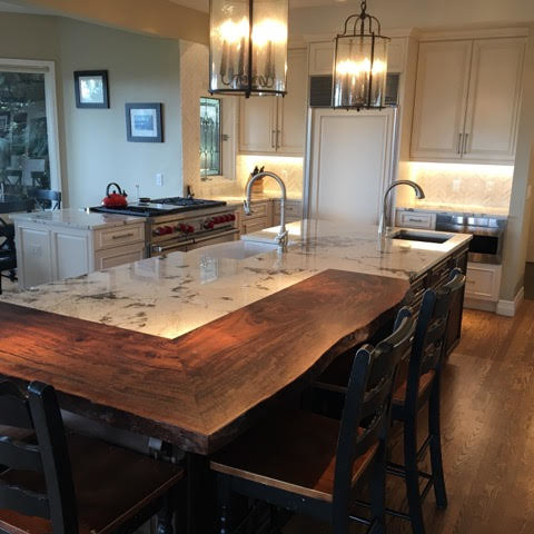 Mid-sized transitional u-shaped medium tone wood floor kitchen photo in Denver with a farmhouse sink, raised-panel cabinets, white cabinets, marble countertops, white backsplash, stone tile backsplash, paneled appliances and an island