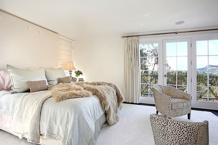 Large contemporary master bedroom in Los Angeles with white walls and dark hardwood floors.
