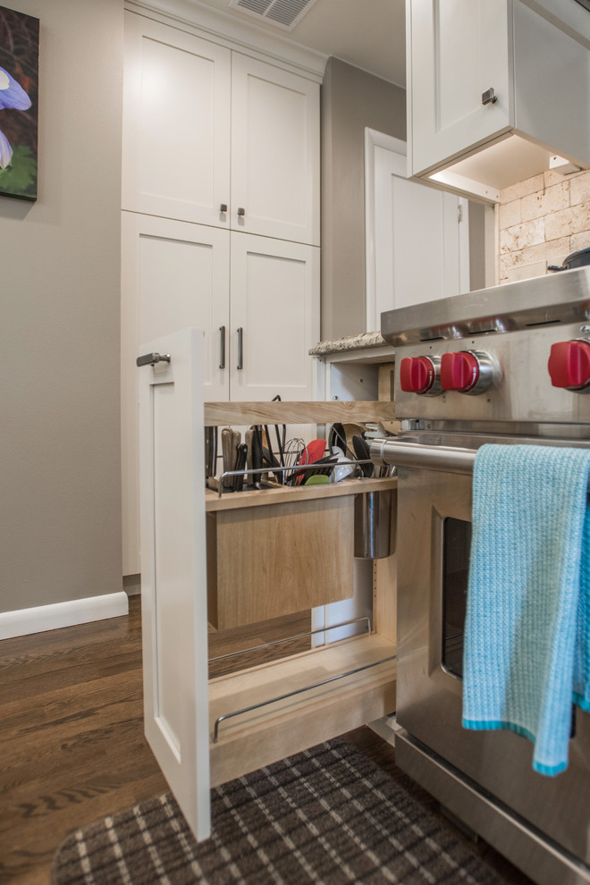 Eat-in kitchen - large transitional u-shaped medium tone wood floor and brown floor eat-in kitchen idea with an undermount sink, shaker cabinets, white cabinets, granite countertops, beige backsplash, travertine backsplash, paneled appliances and an island