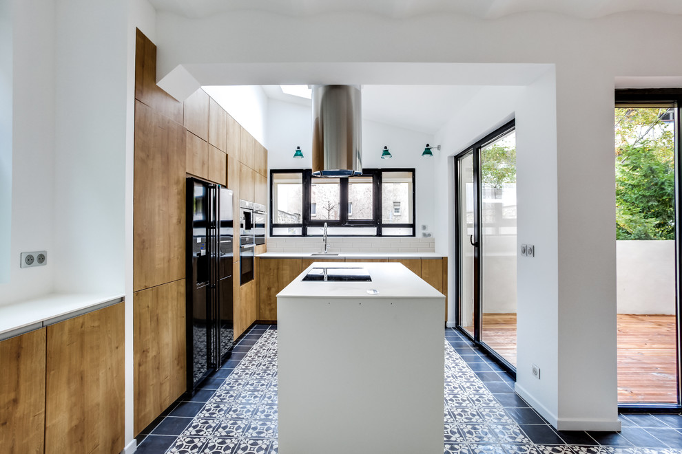 Design ideas for a large industrial l-shaped open plan kitchen in Paris with light wood cabinets, laminate benchtops, beige splashback, matchstick tile splashback, black appliances, cement tiles, an undermount sink, beaded inset cabinets, with island and black floor.
