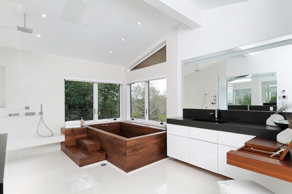This is an example of a large contemporary master bathroom in San Francisco with flat-panel cabinets, white cabinets, an open shower, white walls, porcelain floors, an integrated sink, solid surface benchtops and an open shower.