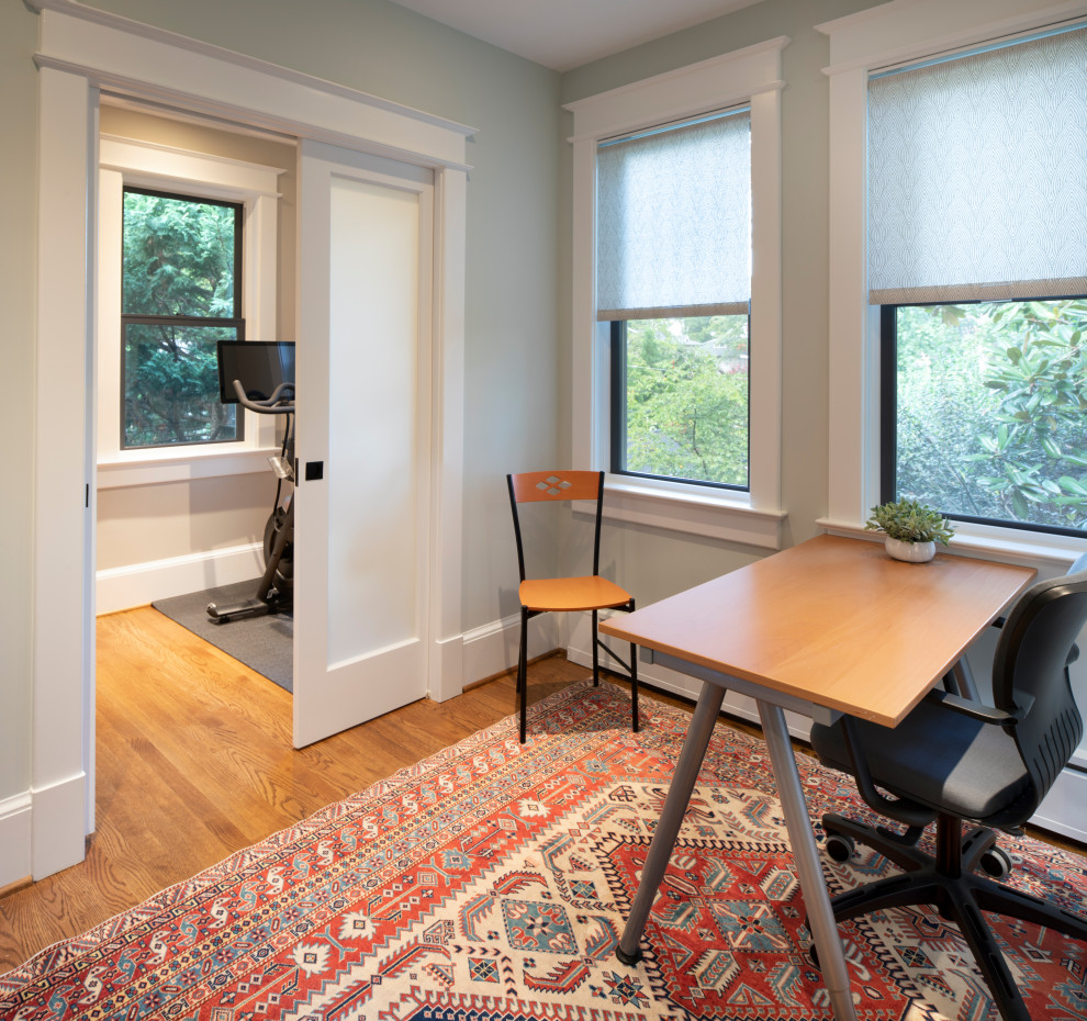 Imagen de despacho contemporáneo con paredes grises, suelo de madera en tonos medios, escritorio independiente y suelo marrón