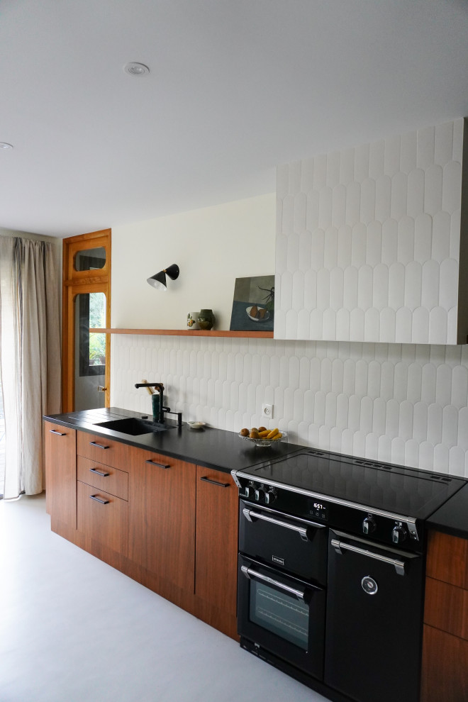Foto på ett stort funkis vit kök, med betonggolv, vitt golv, en undermonterad diskho, luckor med profilerade fronter, skåp i mörkt trä, vitt stänkskydd, stänkskydd i keramik och integrerade vitvaror