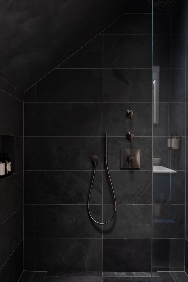 Inredning av ett modernt litet vit vitt badrum med dusch, med släta luckor, blå skåp, våtrum, en vägghängd toalettstol, svart kakel, porslinskakel, ett nedsänkt handfat, bänkskiva i akrylsten, svart golv och med dusch som är öppen
