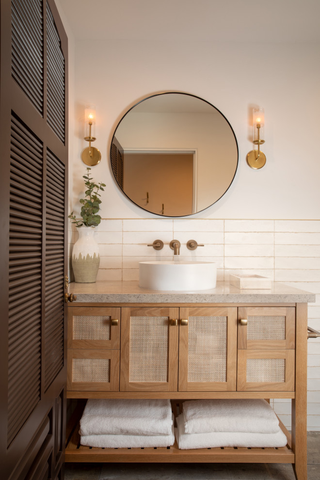 Пример оригинального дизайна: маленькая ванная комната в средиземноморском стиле с плоскими фасадами, светлыми деревянными фасадами, открытым душем, биде, белой плиткой, цементной плиткой, белыми стенами, полом из известняка, душевой кабиной, накладной раковиной, столешницей из известняка, серым полом, бежевой столешницей, сиденьем для душа, тумбой под одну раковину и встроенной тумбой для на участке и в саду