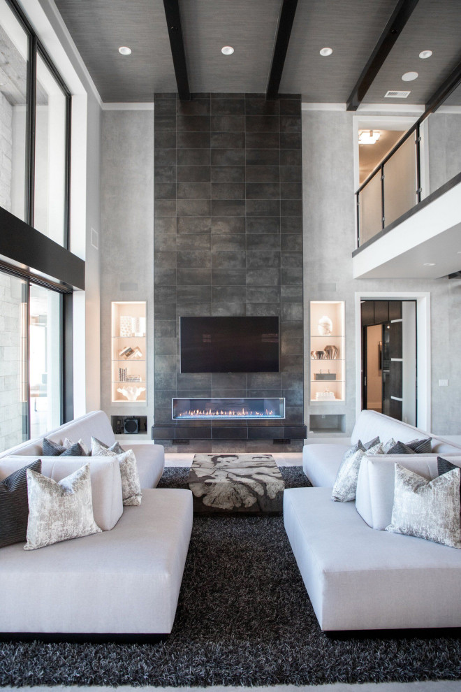 Photo of an expansive modern formal open plan living room in Orange County with grey walls, carpet, a ribbon fireplace, a stone fireplace surround, a wall mounted tv, grey floors and a vaulted ceiling.