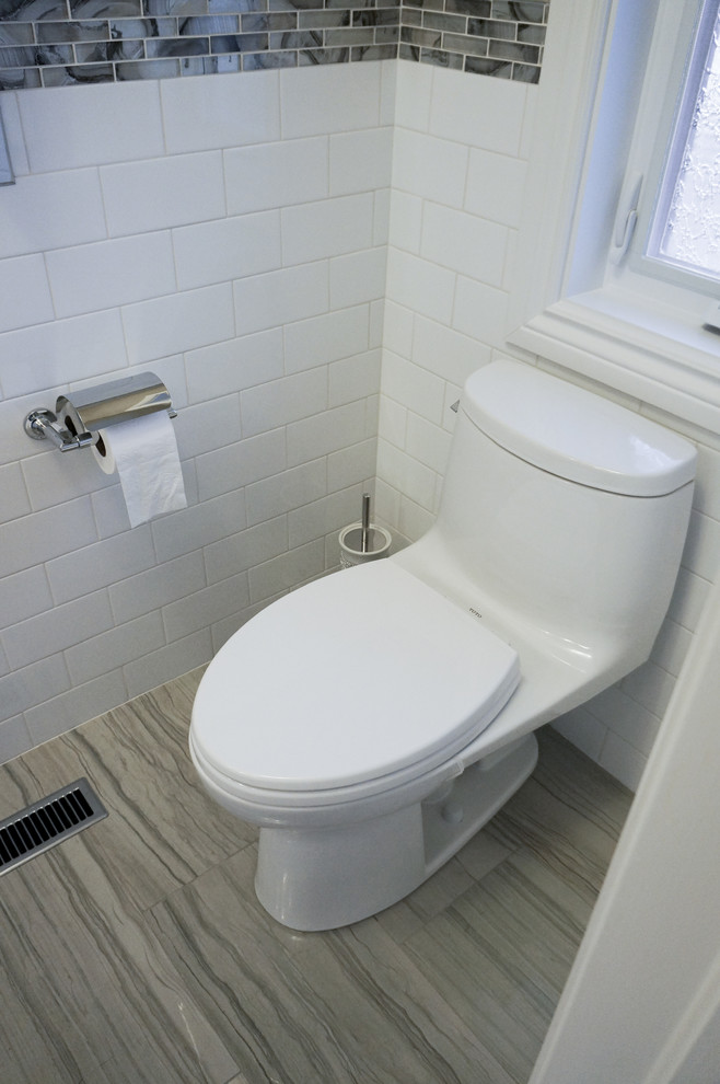 This is an example of a small contemporary cloakroom in Toronto with a vessel sink, engineered stone worktops, a one-piece toilet, multi-coloured tiles, shaker cabinets and white cabinets.