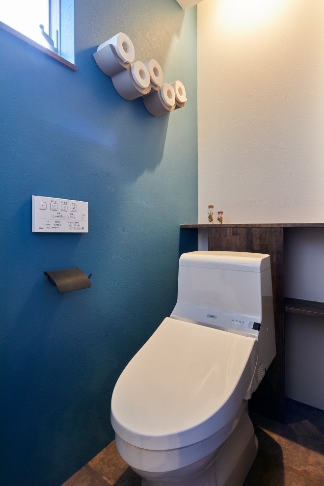 На фото: туалет в восточном стиле с синими стенами, полом из винила, серым полом, потолком с обоями и обоями на стенах с