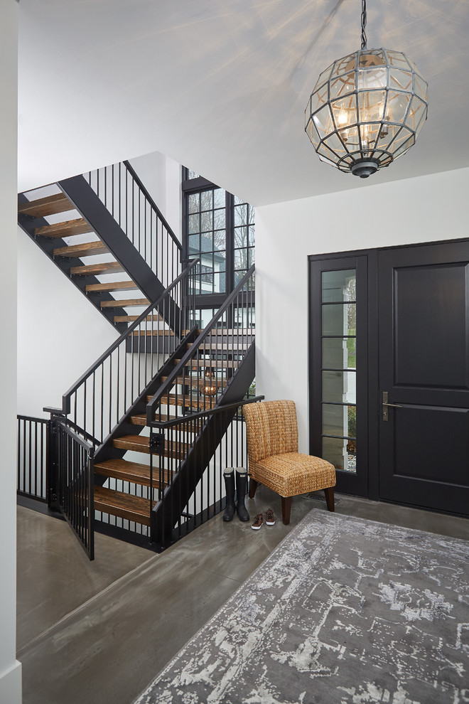 Inspiration for a large transitional foyer in Grand Rapids with white walls, concrete floors, a single front door, a black front door and grey floor.