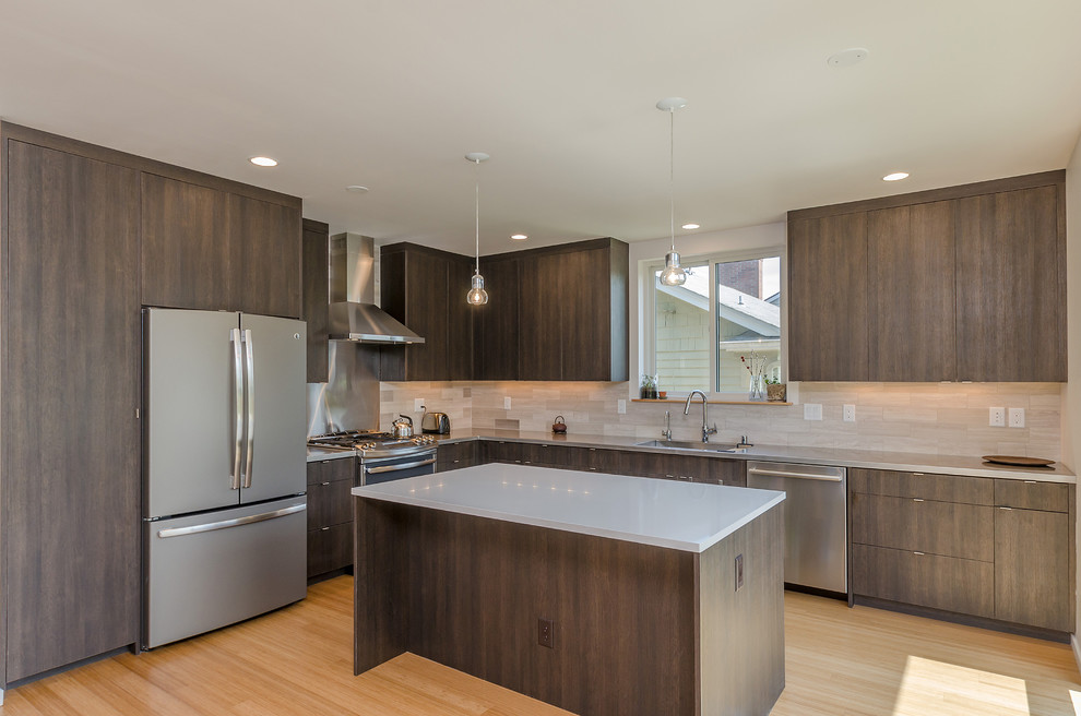 Inspiration for a mid-sized modern l-shaped open plan kitchen in Seattle with an integrated sink, flat-panel cabinets, dark wood cabinets, quartz benchtops, beige splashback, porcelain splashback, stainless steel appliances, bamboo floors and with island.