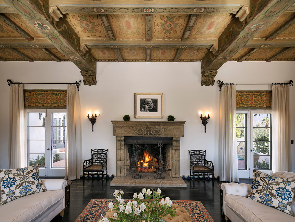 Design ideas for an expansive mediterranean formal enclosed living room in Santa Barbara with white walls, dark hardwood floors, a standard fireplace, a stone fireplace surround, no tv and black floor.