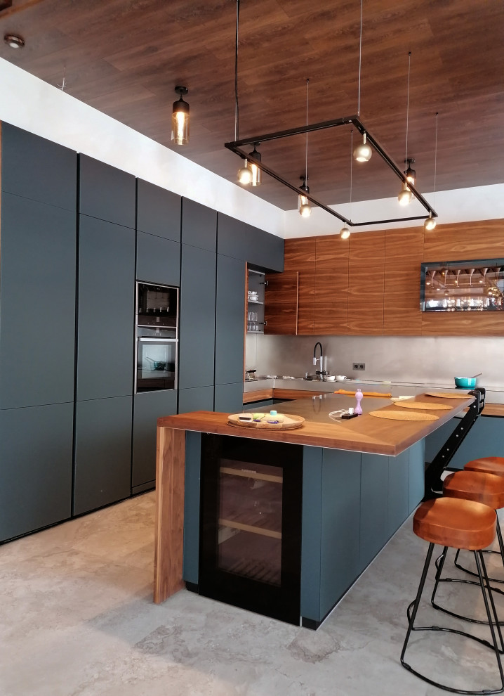 This is an example of a large contemporary l-shaped eat-in kitchen in Moscow with a single-bowl sink, flat-panel cabinets, black cabinets, wood benchtops, grey splashback, panelled appliances, porcelain floors, with island, grey floor, brown benchtop and exposed beam.