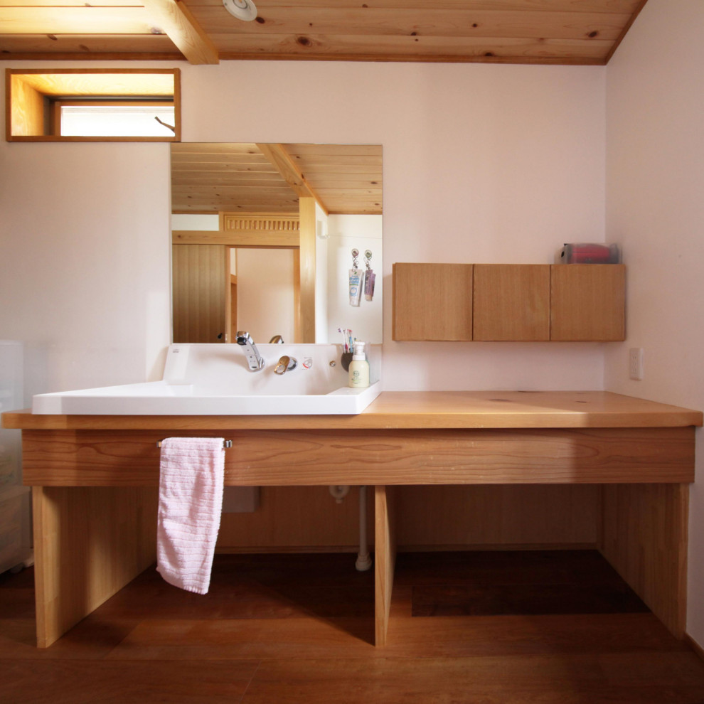 Источник вдохновения для домашнего уюта: туалет с оранжевыми фасадами, столешницей из дерева и встроенной тумбой