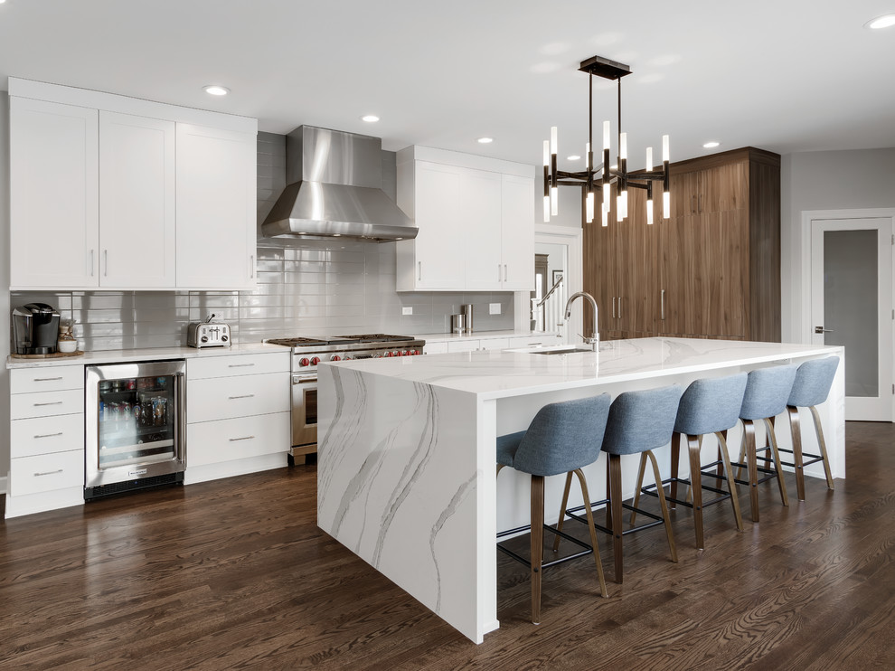 Inspiration for a large contemporary l-shaped kitchen in Other with an undermount sink, flat-panel cabinets, white cabinets, quartz benchtops, grey splashback, glass tile splashback, panelled appliances, with island, brown floor, white benchtop and dark hardwood floors.