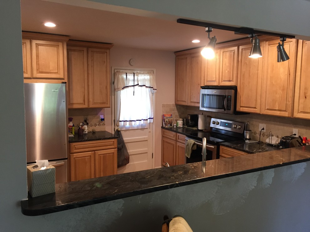 This is an example of a large transitional l-shaped eat-in kitchen in Indianapolis with an undermount sink, raised-panel cabinets, light wood cabinets, granite benchtops, beige splashback, ceramic splashback, stainless steel appliances, light hardwood floors and a peninsula.