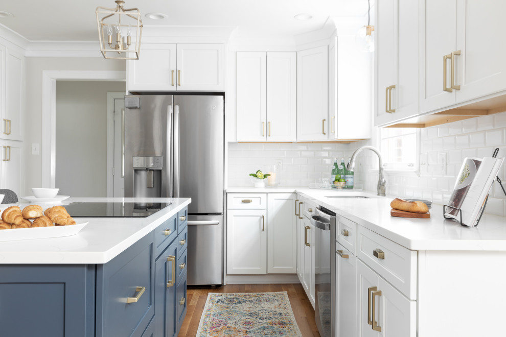 Design ideas for a transitional u-shaped kitchen in Other with subway tile splashback, stainless steel appliances, medium hardwood floors, with island, white benchtop, an undermount sink, shaker cabinets, white cabinets, white splashback and brown floor.