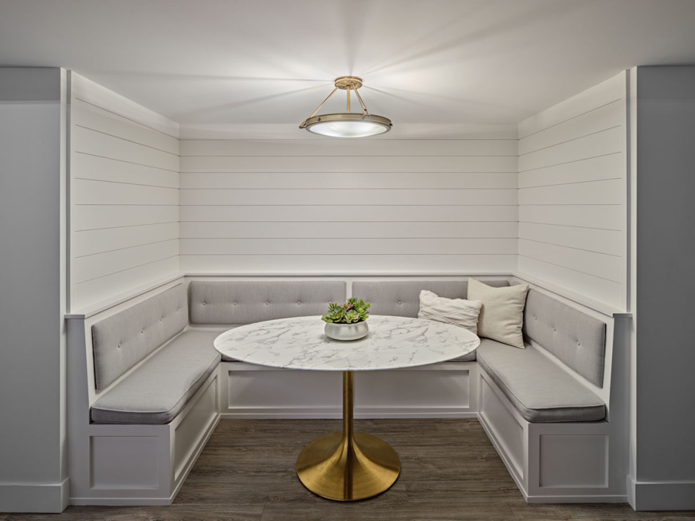 На фото: столовая среднего размера в современном стиле с с кухонным уголком, белыми стенами, светлым паркетным полом, стандартным камином, фасадом камина из кирпича, серым полом и балками на потолке