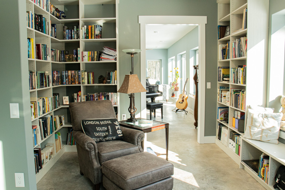 Idee per un soggiorno chic di medie dimensioni e aperto con libreria, pareti verdi, pavimento in cemento e pavimento grigio