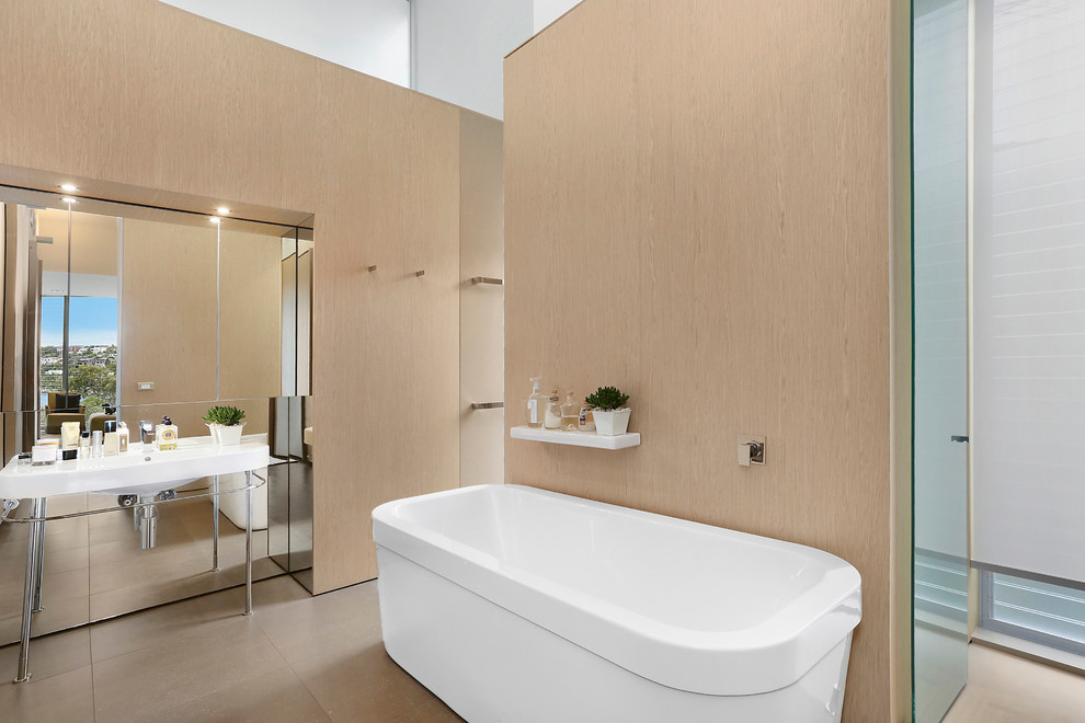 Inspiration for a large contemporary master bathroom in Sydney with a freestanding tub, an open shower, a wall-mount toilet, travertine floors and a trough sink.