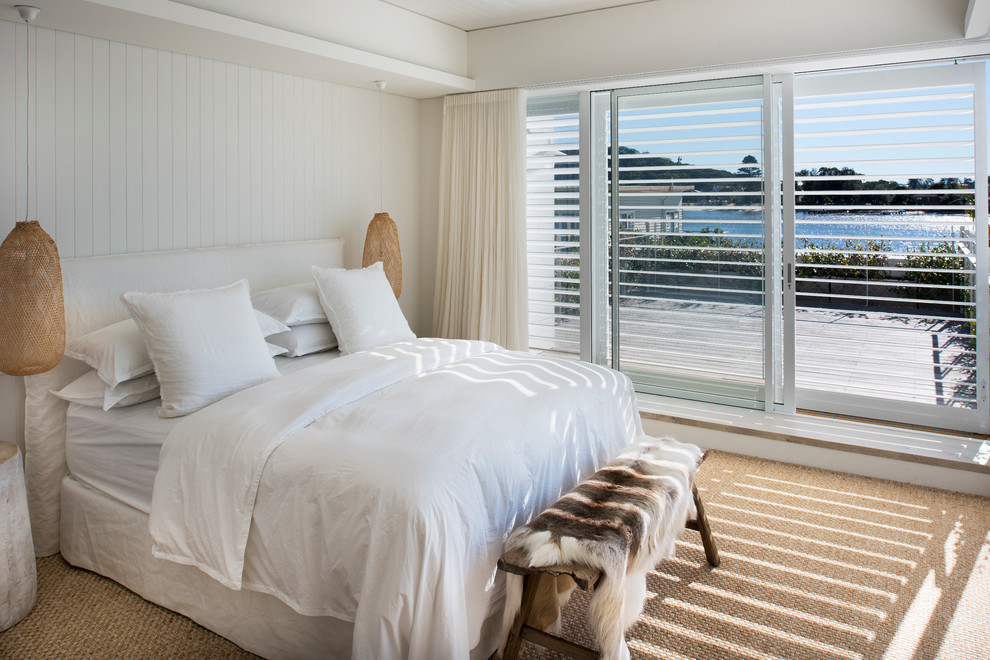 Inspiration for a beach style bedroom in Sydney with white walls, carpet and no fireplace.