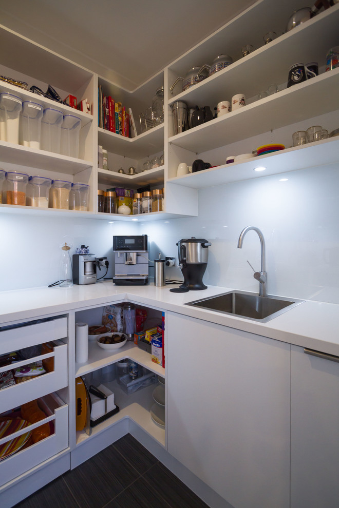 Photo of a large transitional galley eat-in kitchen in Melbourne with a drop-in sink, shaker cabinets, white cabinets, quartz benchtops, stone slab splashback, black appliances and with island.