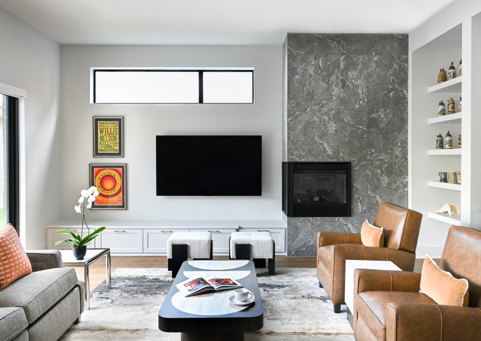 This is an example of a contemporary living room in Houston with white walls, medium hardwood floors, a corner fireplace, a wall-mounted tv and brown floor.