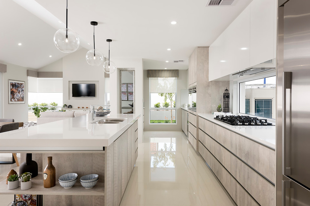 Inspiration for a large contemporary galley open plan kitchen in Perth with a double-bowl sink, shaker cabinets, light wood cabinets, quartz benchtops, glass sheet splashback, stainless steel appliances, porcelain floors and with island.