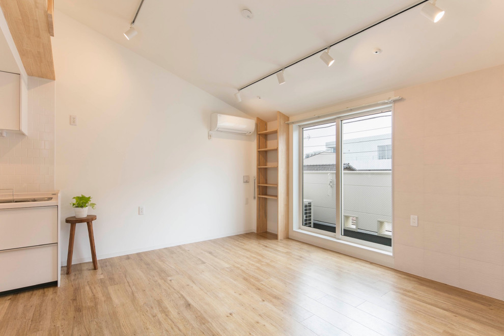 Photo of a mid-sized scandinavian open concept living room in Tokyo with white walls, light hardwood floors, beige floor, wallpaper and brick walls.