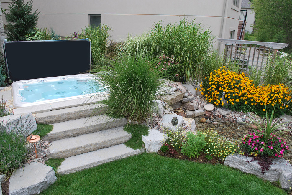 This is an example of a mid-sized traditional backyard aboveground pool in Toronto with a hot tub.