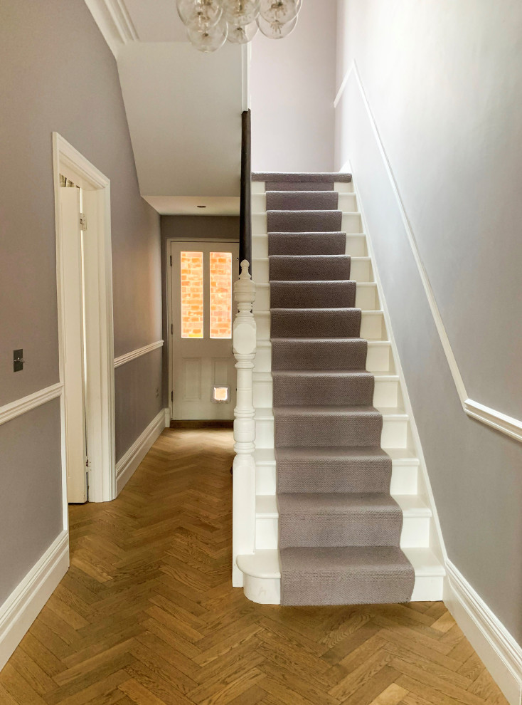 Inspiration for a large contemporary carpeted u-shaped wood railing staircase remodel in Kent