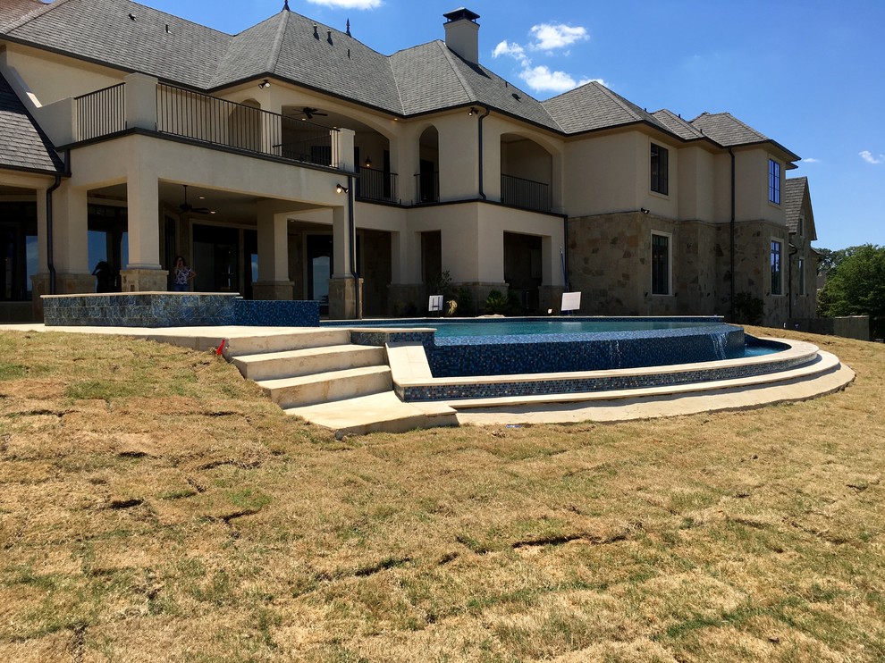 Inspiration for a mid-sized transitional backyard concrete and custom-shaped infinity hot tub remodel in Austin