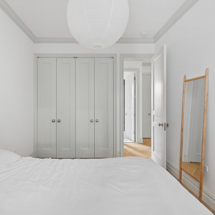 Esempio di una camera matrimoniale design di medie dimensioni con pareti bianche, parquet chiaro e pavimento beige
